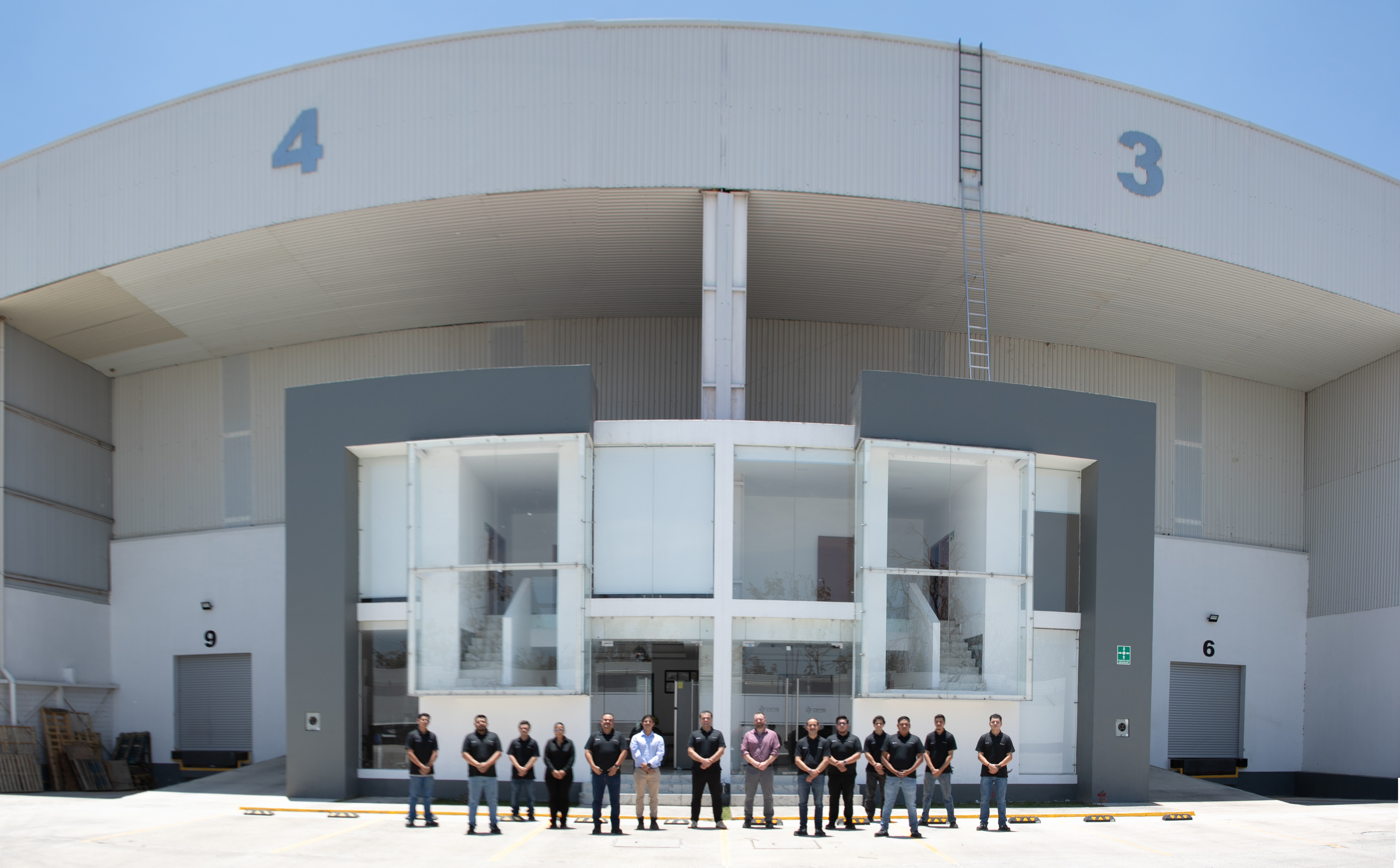 The AMS team in front of the manufacturing facility